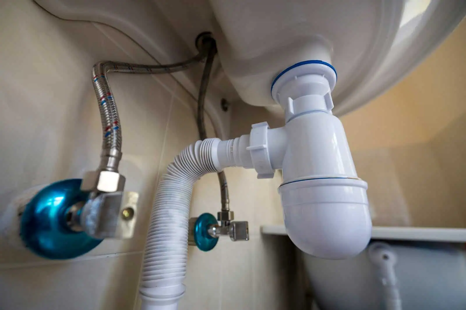Corrosion-resistant plumbing pipes and fittings under a sink for residential plumbing repair.
