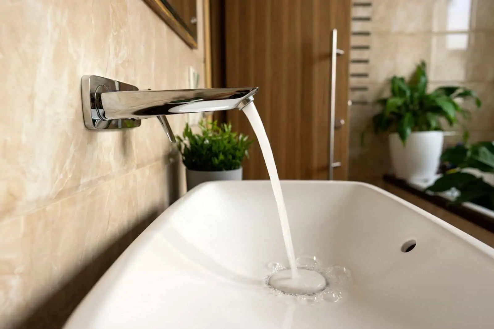 Faucet with flowing water in a contemporary bathroom setting.